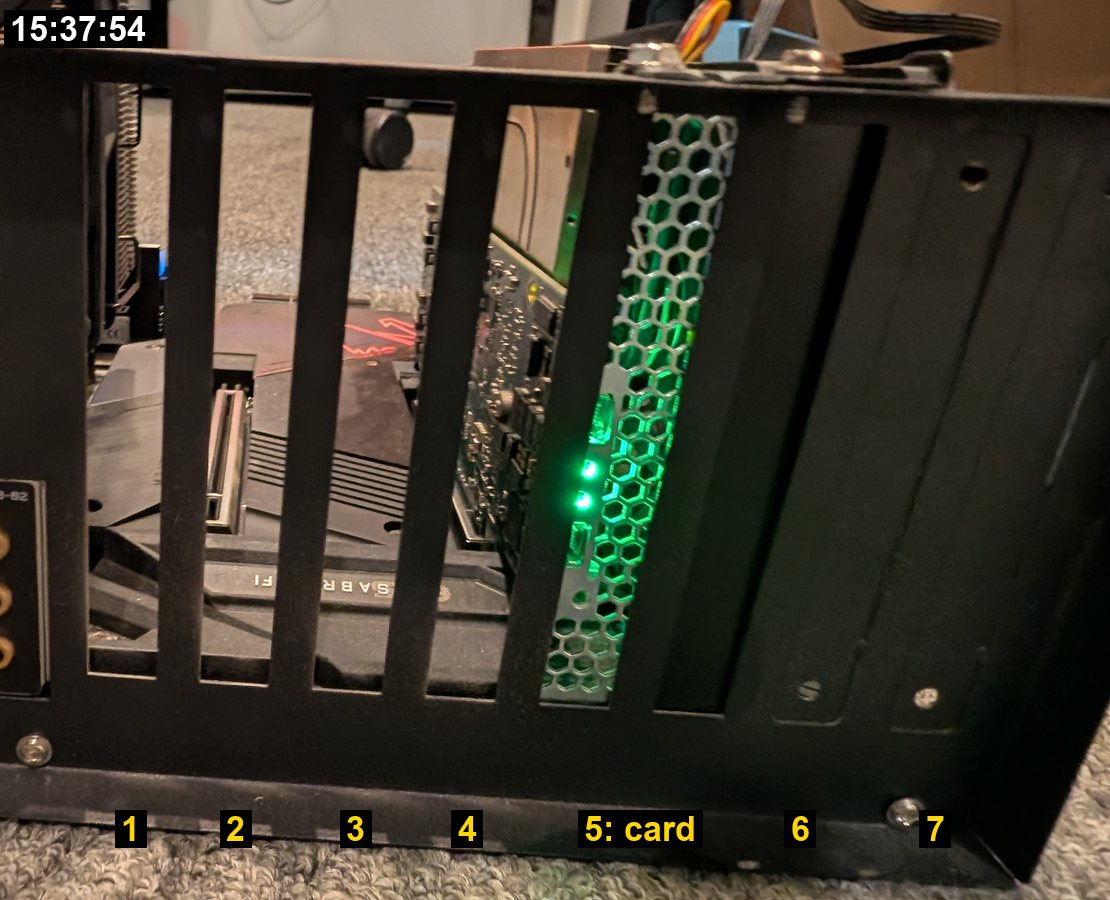 The frame's rear wall from outside: seven slot positions numbered 1 to 7, the card's green-lit vented bracket in position 5.